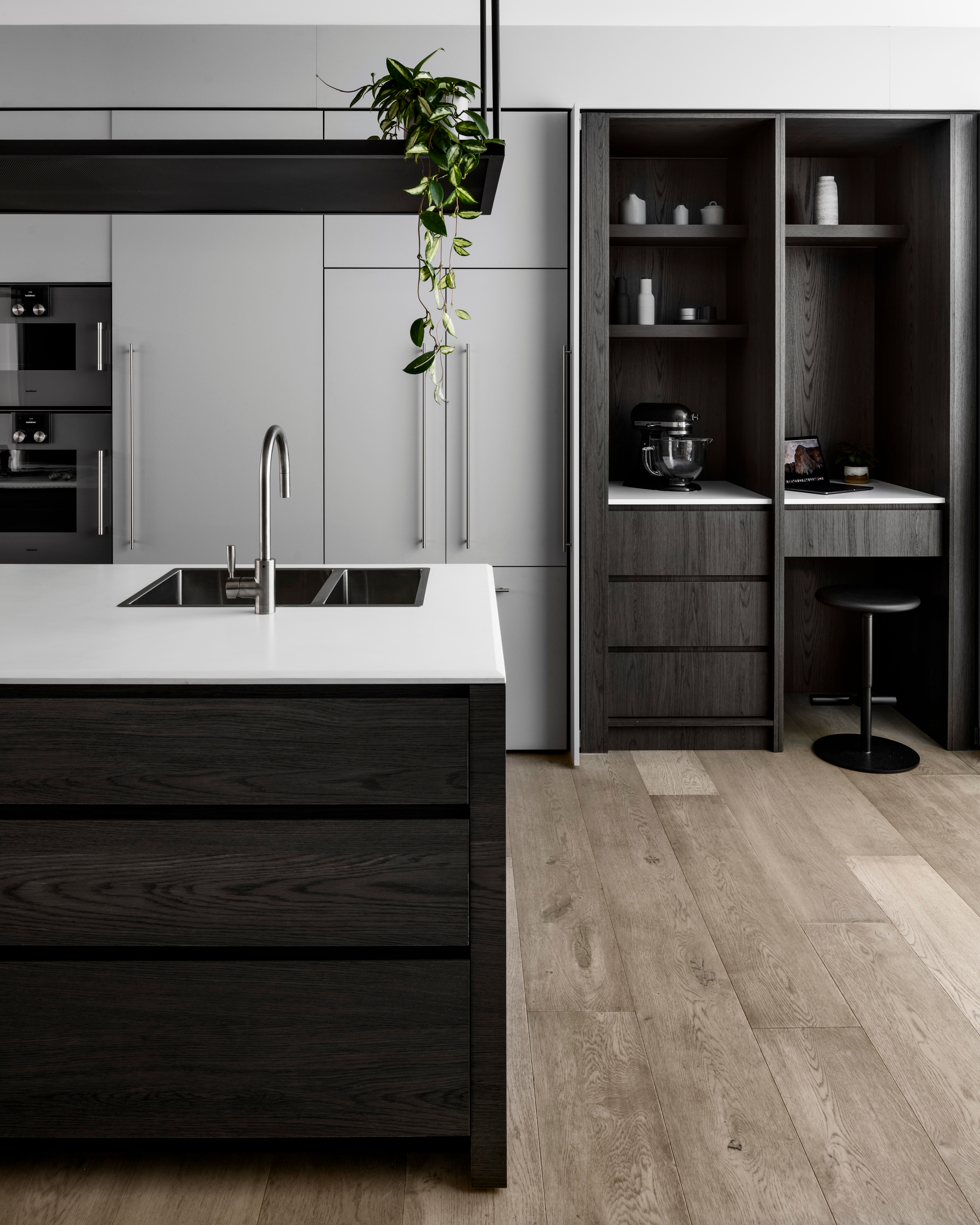 A sleek kitchen design with wooden floors and custom joinery crafted from Cellupal stunningly accurate timber-look laminate in Sparka, a grey decor with 3D woodgrain feature and a super matt finish.
